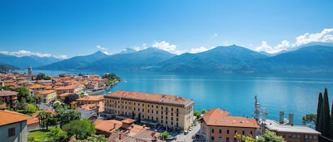 A coastal town with buildings along the waterfront, a clear view of the lake, and mountains in the background.