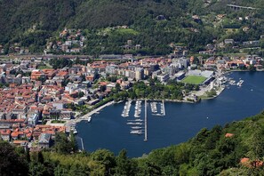 Eine Küstenstadt mit dichter Bebauung, einem Yachthafen mit Booten und einer hügeligen Kulisse.
