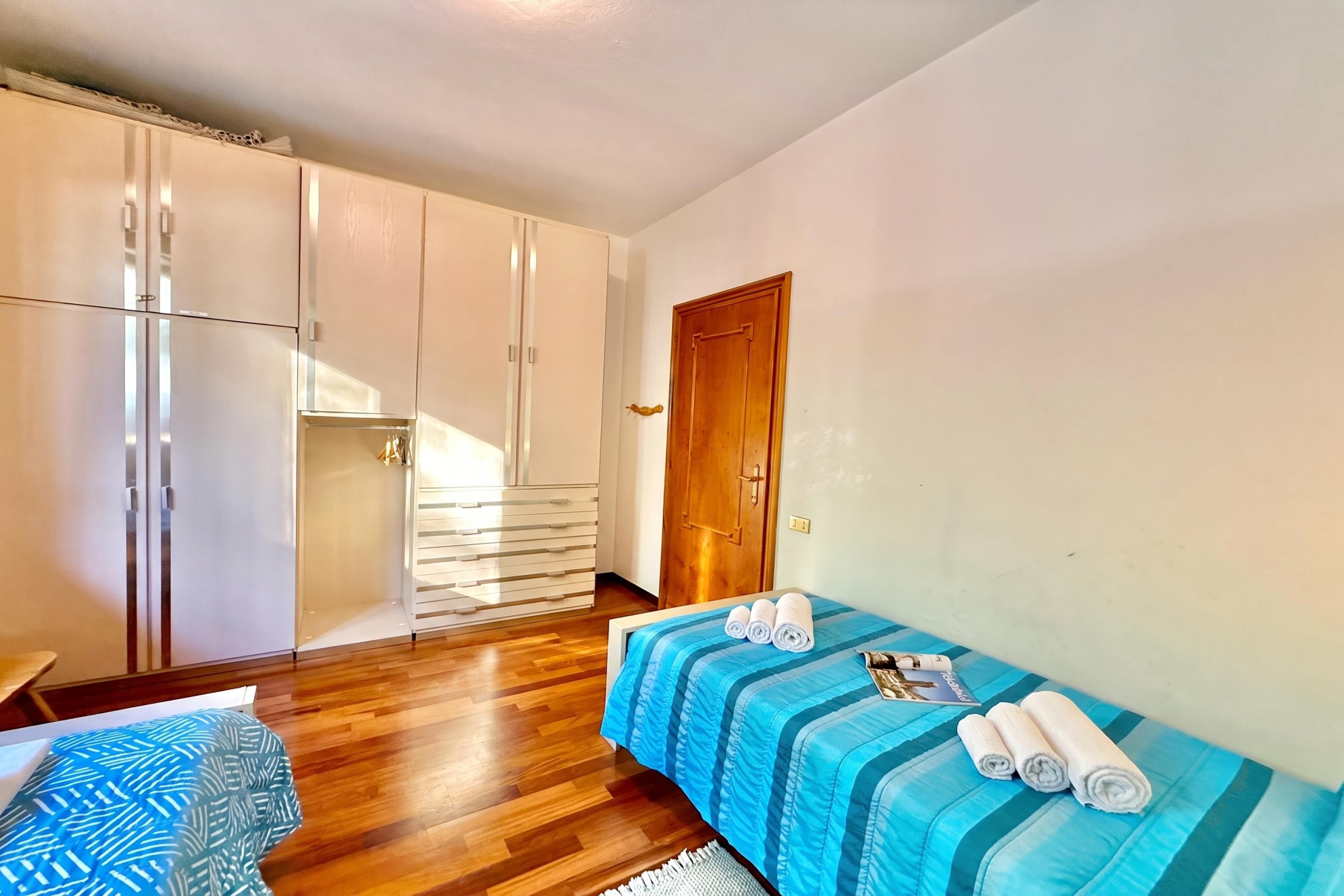 Un dormitorio con cama, puerta de madera y armario.