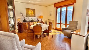 A dining area with a table, chairs, and a view of a lake through large windows. - Isola Vista - Terrazzo (Sala Comacina)