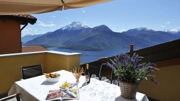 Mesa lista para comer con vista a montañas y un lago.