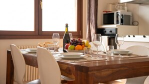 A dining table set with plates, glasses, and a fruit bowl. - Alto Perledo Terrazzo (Perledo)