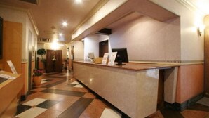 Ein Hotel-Rezeptionsbereich mit einer Marmor-Theke, einem Empfangstresen und einem Check-in-Bereich.
