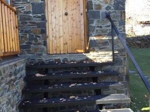 A stone building with wooden steps and a door.