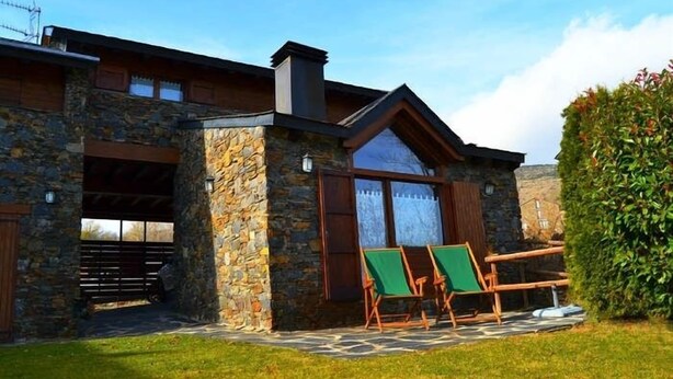 A stone building with a covered patio, two green lawn chairs, and a hedge. - House 3 rooms Fireplace, Garden & Dryer (Guils de Cerdanya)