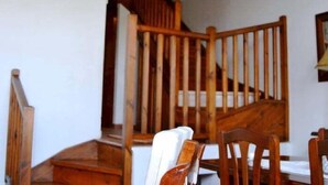 A wooden staircase with a white wall and a hanging light fixture. - House 3 rooms Fireplace, Garden & Dryer (Guils de Cerdanya)