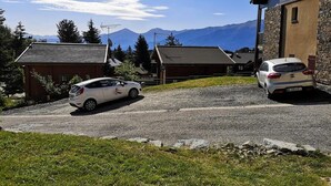 Un edificio con fachada de piedra, un camino de grava y un coche estacionado al frente.