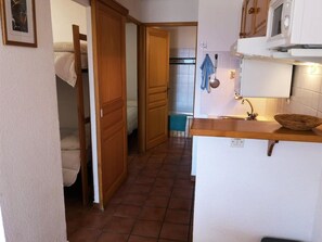 A compact kitchen with a wooden countertop, a sink, and a microwave.