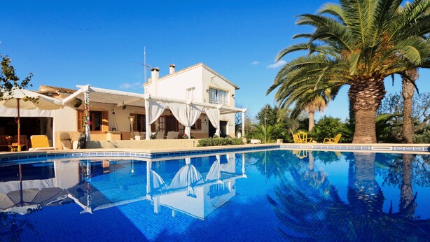Una piscina con una casa al fondo.