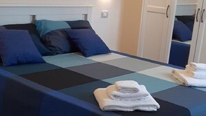 Hotellihuone, jossa on suuri sänky, vaatekaappi ja peili.