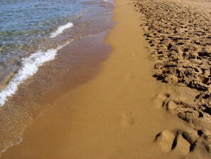 A sandy beach with footprints leading into the water. - Rouladina Apt 3 (Stalos)