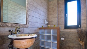 A bathroom with a vintage sink, a mirror, a window, and a towel rack. - Villa Amvrosia (Armeni)
