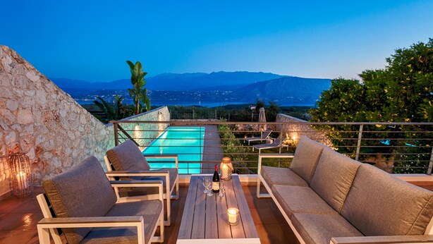 Une terrasse avec piscine, des sièges et une vue sur les montagnes.