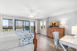 A bedroom with a large bed, a desk, a chair, a dresser, and a balcony with a view of the ocean. - ✨Walk2Beach-Lake Front-5 Pools-Pet Friendly-2 Screened Porches-3BR Family Tides✨ (Miramar Beach)