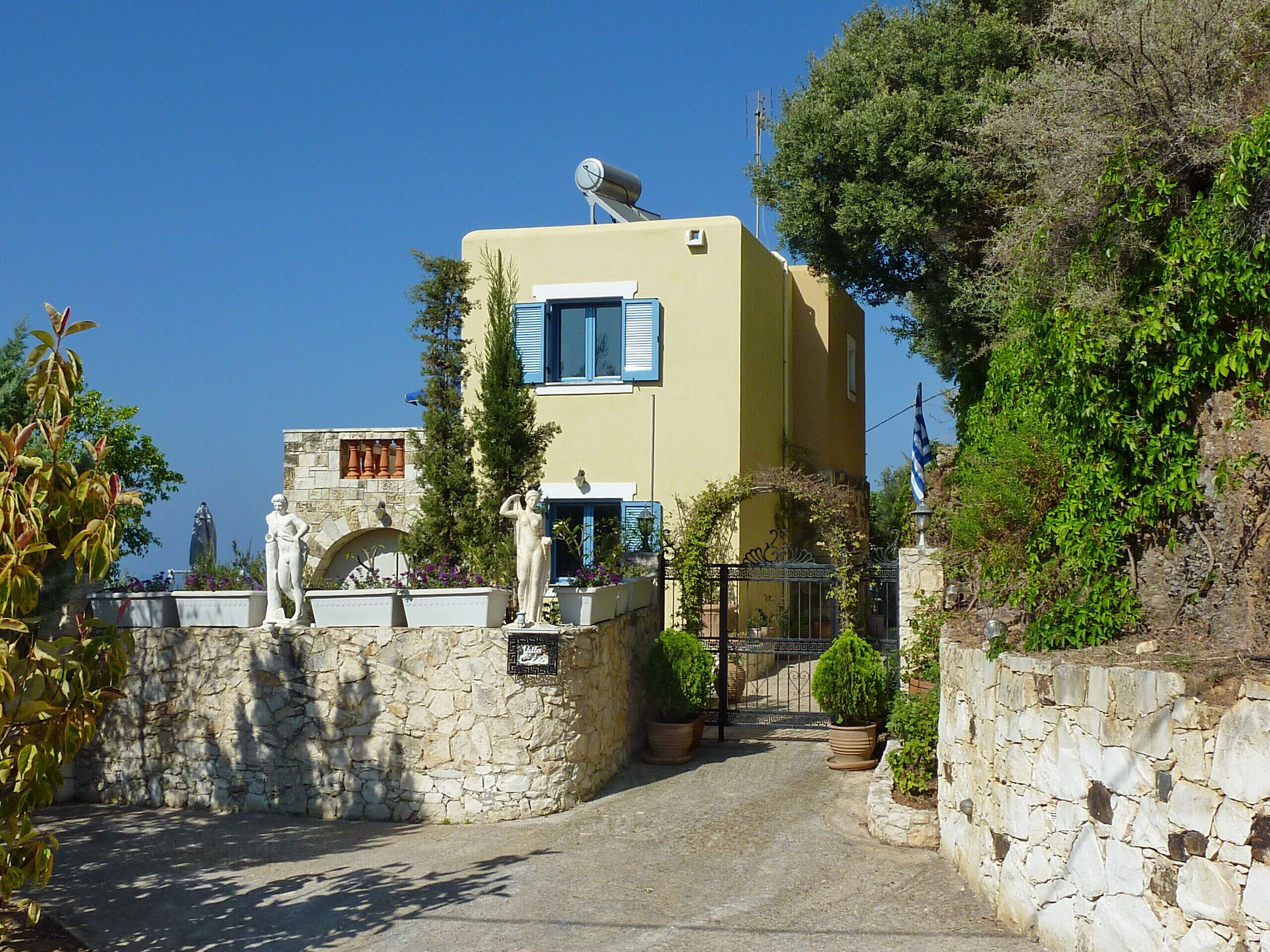 A building with a stone wall entrance, a statue, and a flag.