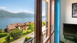 A room with a large window overlooking a lake and mountains. - Balcone di Noa e Stella (Menaggio)