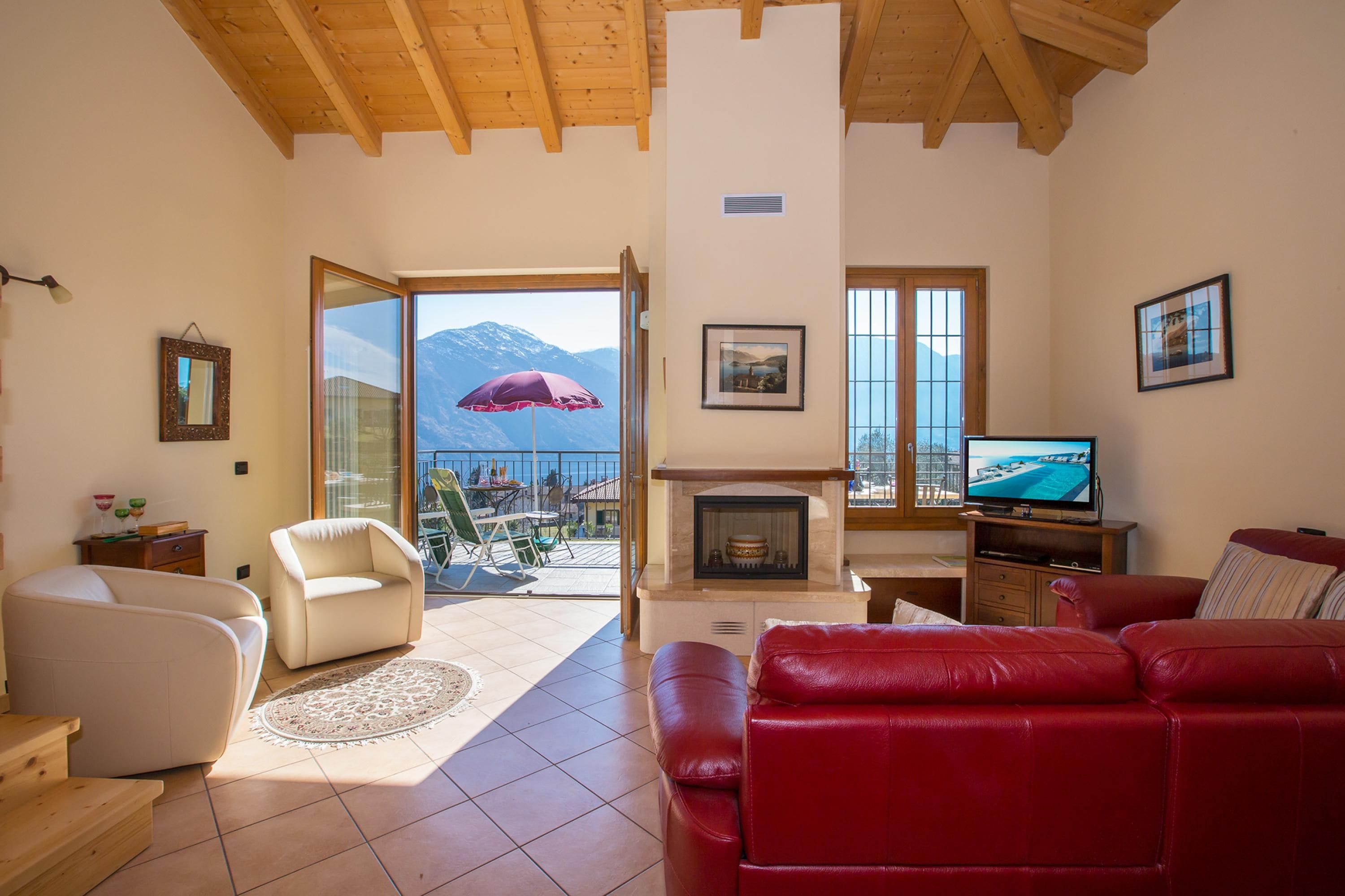 A living room with a fireplace, a television, and a red sofa.