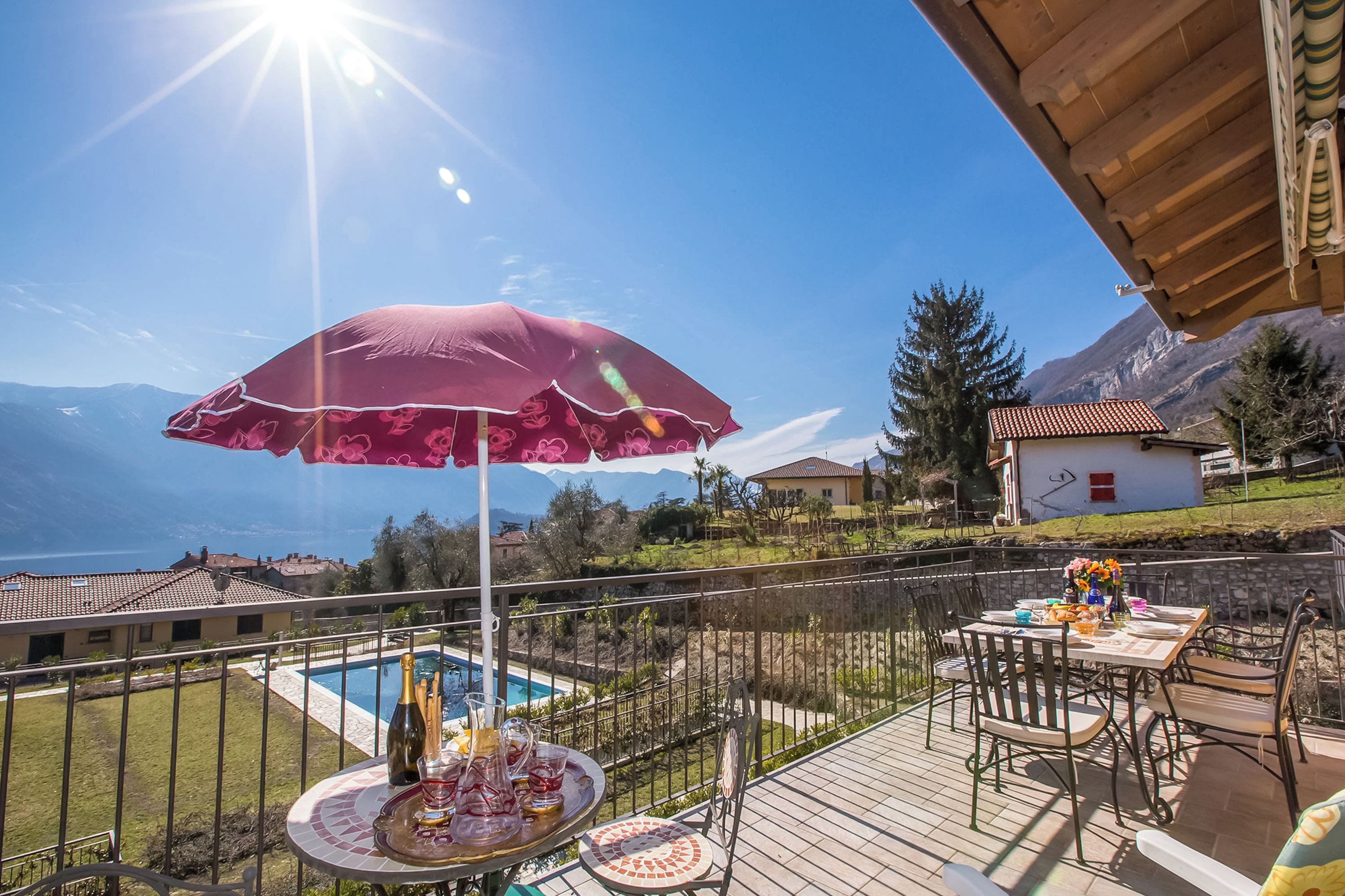 A terrace with a pool, outdoor dining, and a mountain view.