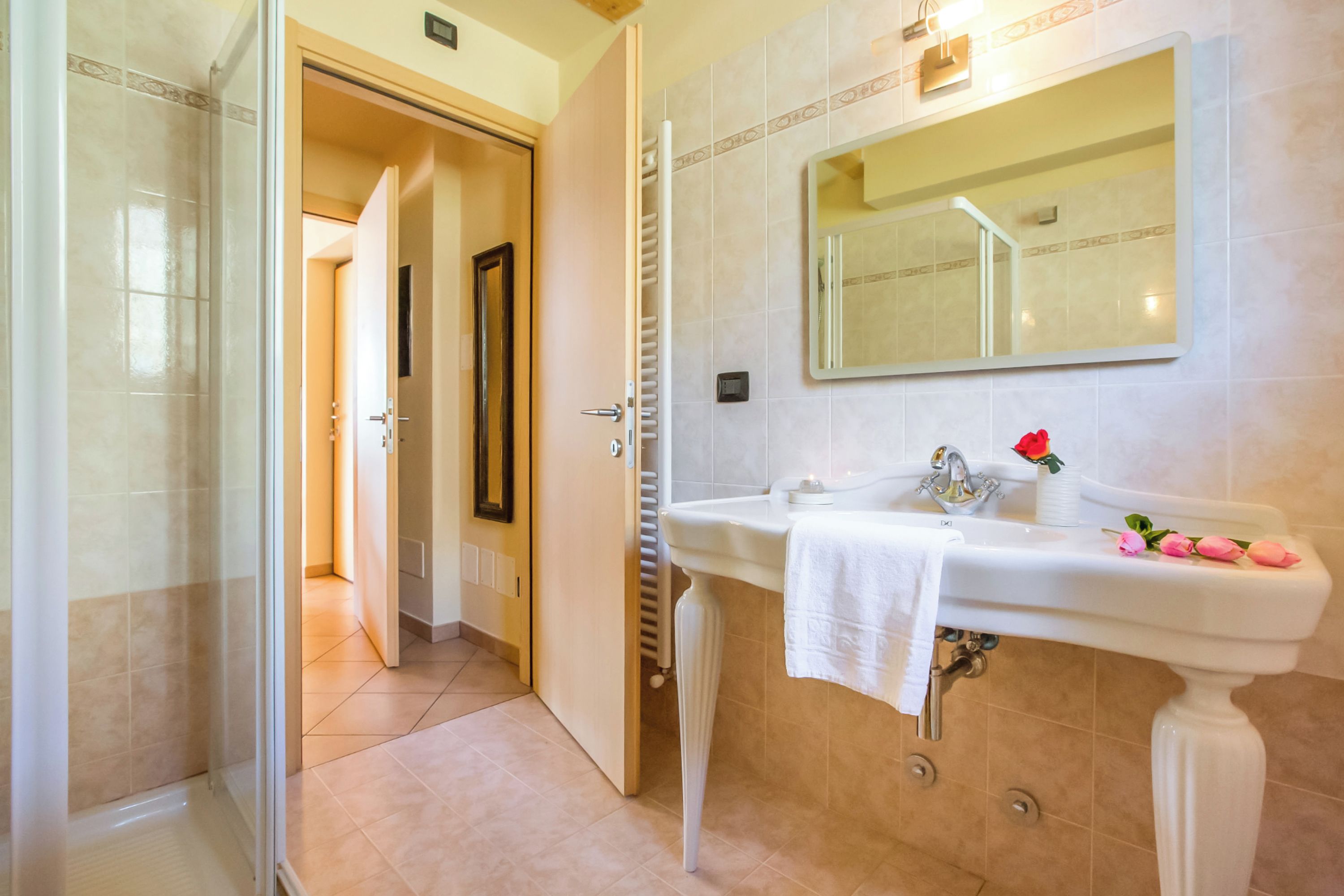 Un baño con un lavamanos blanco, un espejo y una ducha.