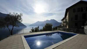 A swimming pool with a view of mountains and a lake. - Colonno Panoramica (Colonno)