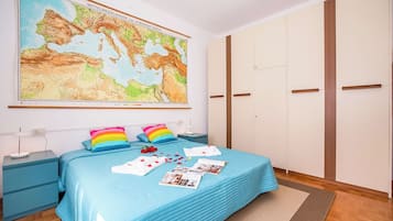 Ein Schlafzimmer mit einem großen Bett, einer Wandkarte und einem Kleiderschrank.