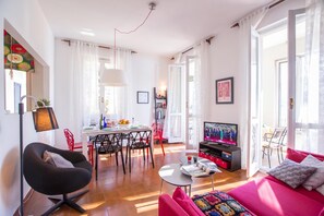 Una sala de estar moderna con comedor, televisor y sofá.