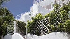 Um edifício branco com uma escadaria que leva a uma varanda.