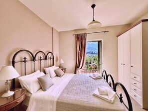Camera da letto con letto, comodino, lampada e vista su un balcone.