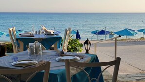 Un restaurante frente al mar, con mesas dispuestas para comer, con vistas al océano.