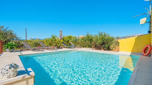 A clear blue pool with lounge chairs and a lifebuoy, surrounded by greenery and a clear sky. - Country Home “Son Serra” in Rural Area with Air Conditioning, Terrace & Garden (Buger)
