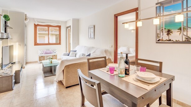 A modern hotel room with a dining area, a bed with a view, and a large window. - Holiday Home Can Jaume with Sea View, Wi-Fi, A/C & Balcony (Puerto de Alcudia)