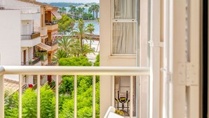 Een balkon met uitzicht op een kustgebied, inclusief gebouwen en palmbomen.