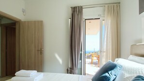 Habitación de hotel con cama, armario de madera y vistas al exterior por una puerta corrediza.