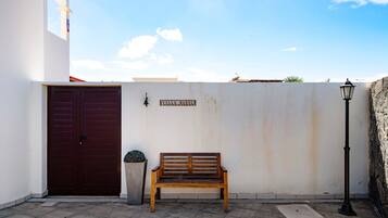 Un banco, una puerta, un cartel en la pared y un farol.