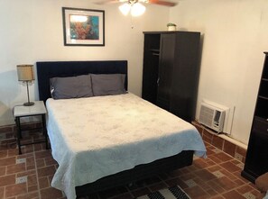 Cozy retreat with a neatly made bed, bedside table, and large wardrobe.