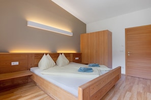 Une chambre à coucher avec un lit en bois, une armoire et une table de chevet.