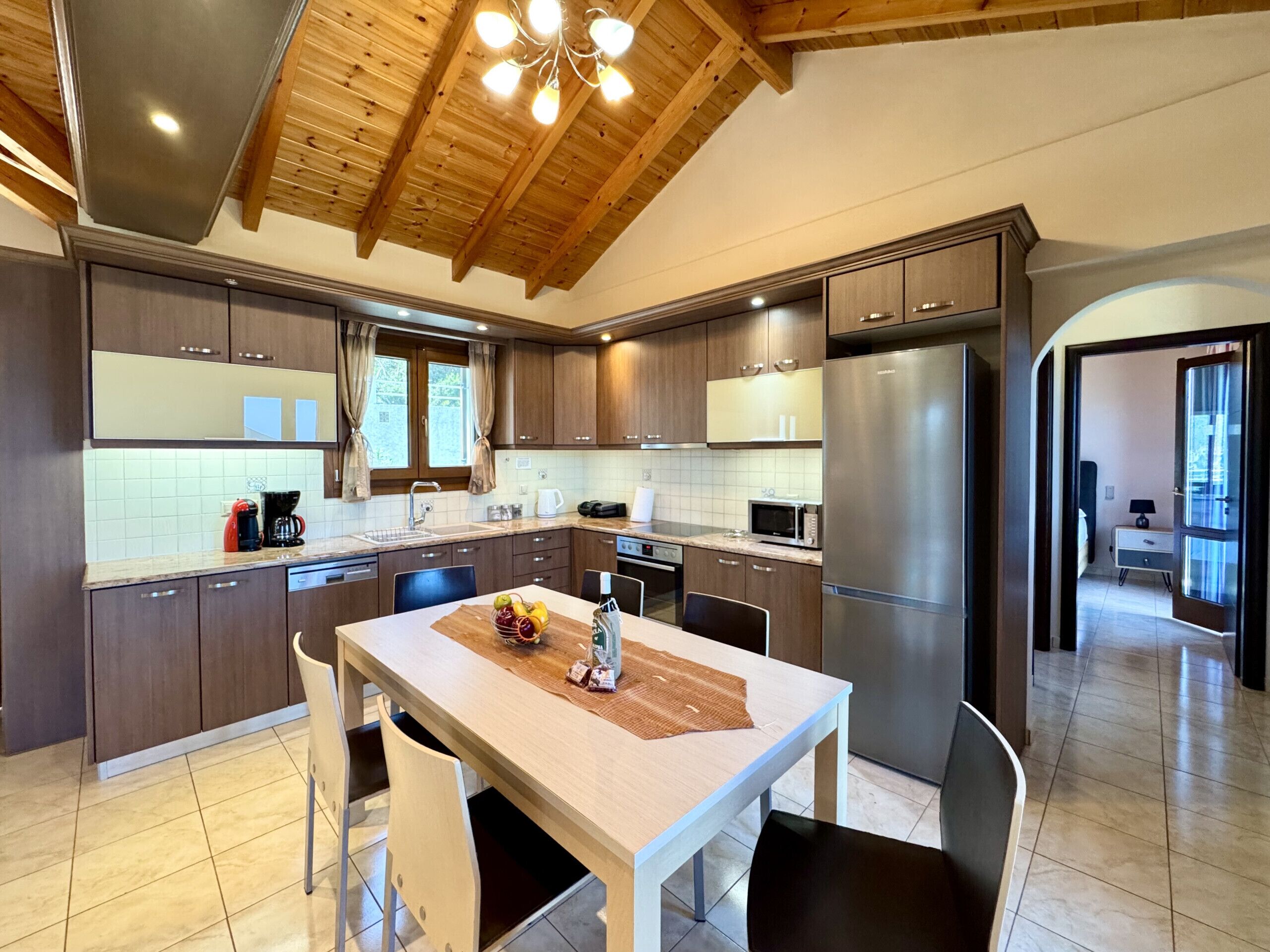 A modern kitchen with wooden cabinets, stainless steel appliances, and a central island with seating.
