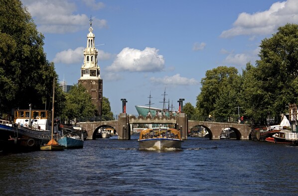 Un canal avec des bateaux, un pont et un beffroi.