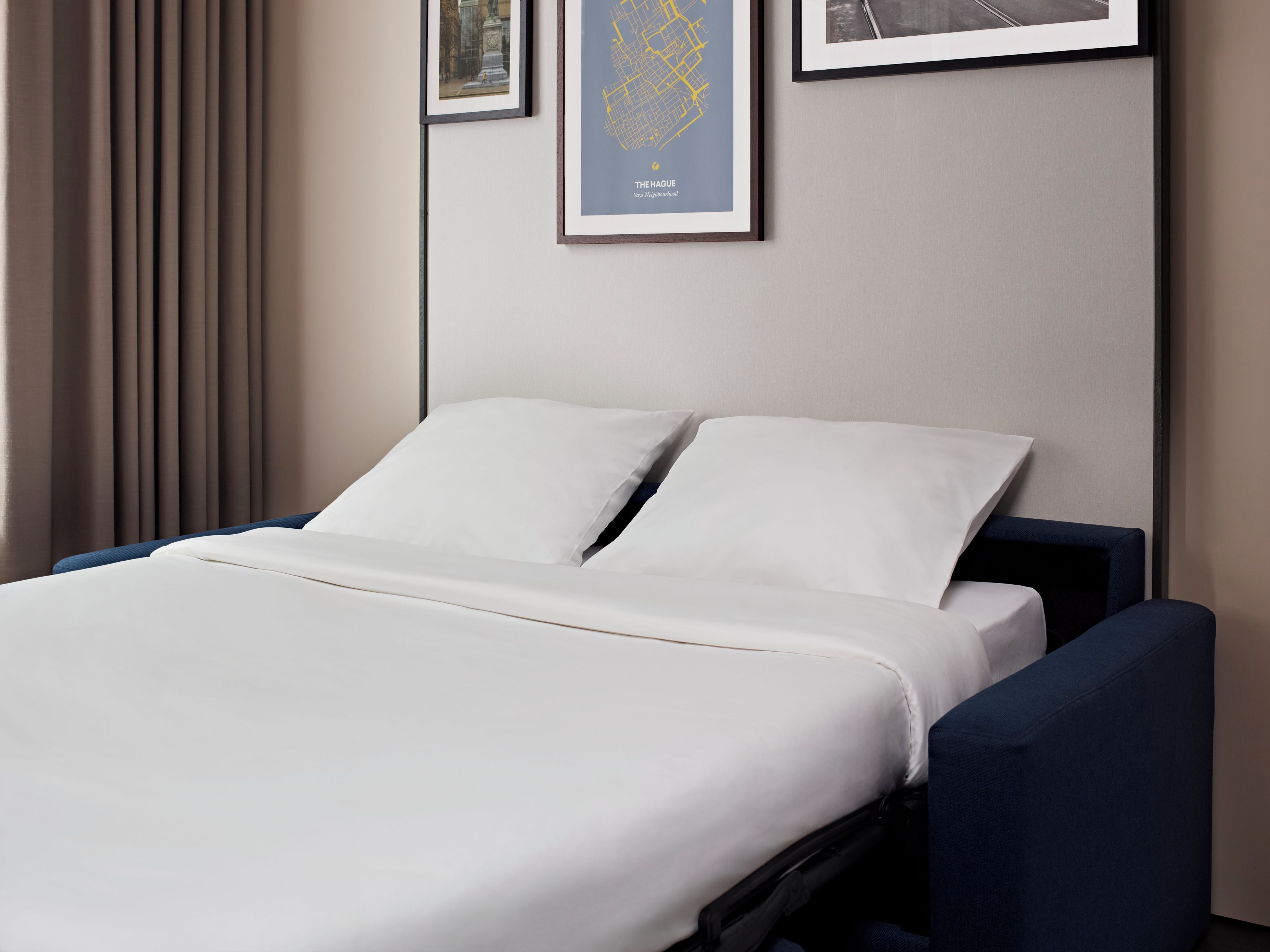 A hotel room with a bed, a headboard, and a wall-mounted map.
