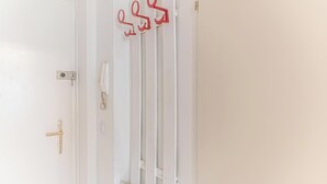 A white door with a gold handle, a white radiator, and a red coat hook. - Modern Apartment in The Heart of Vienna 9 (Vienna)
