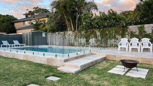 A backyard with a swimming pool, a barbecue grill, and outdoor seating. - 81 Horace St - Wifi, Pool and air conditioning (Shoal Bay)