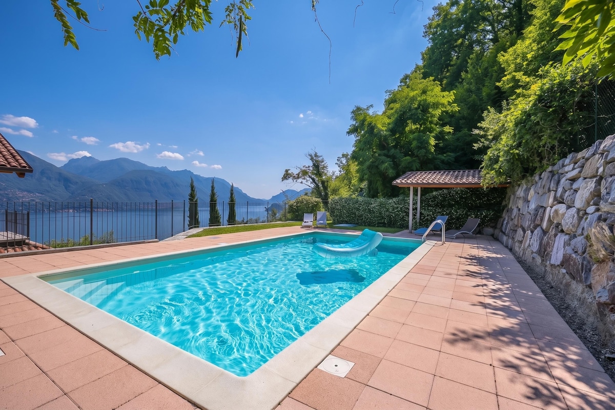 A swimming pool with a view of mountains and a lake.