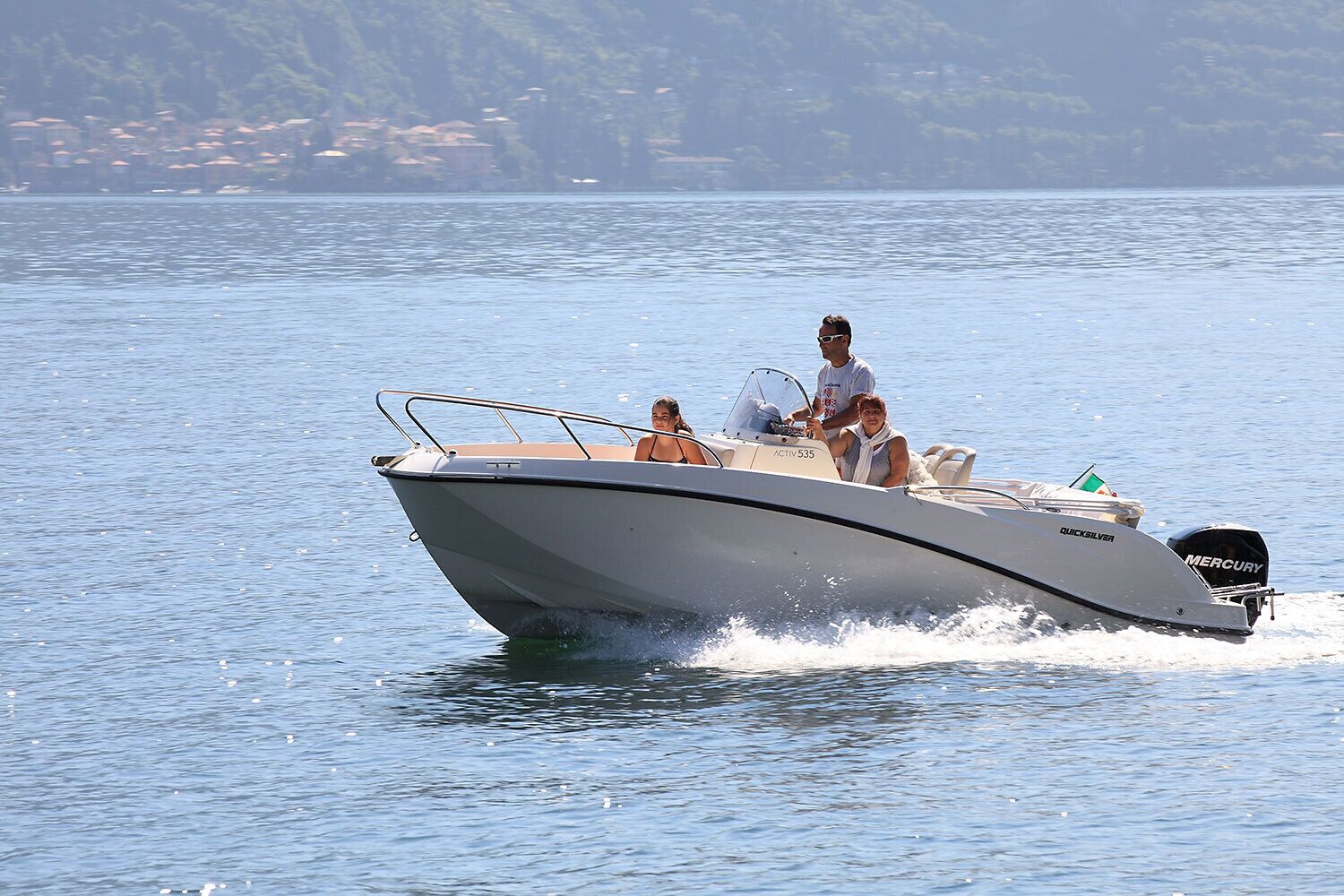 A motorboat with two people on board, moving on a body of water.