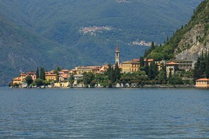 A lakeside town with historic buildings, a prominent church tower, and a hillside backdrop. - Riva Bellano Lavanda (Bellano)