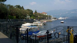 A marina with boats docked, a bridge, and a building in the background.
