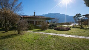 A house with a tiled roof, surrounded by a well-maintained garden and a stone pathway.