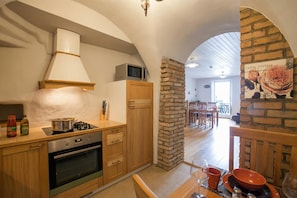 A kitchen with a stove, oven, microwave, and wooden cabinets.