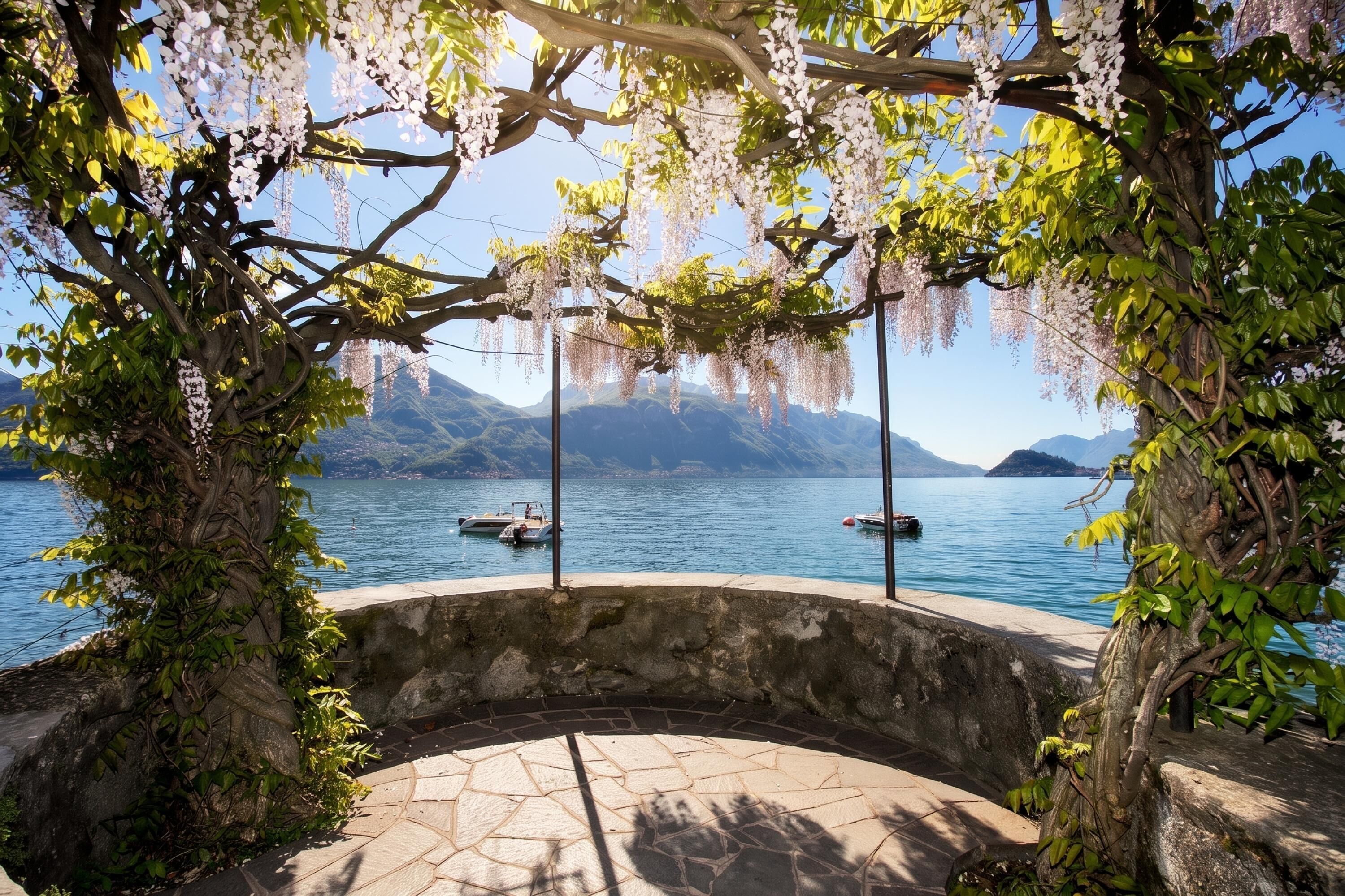 A stone bench with a view of a lake and mountains.