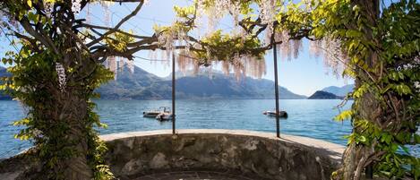 A stone bench with a view of a lake and mountains.
