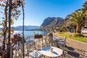 A terrace with outdoor seating, overlooking a lake and mountains. - Nobiallo Fantastico (Menaggio)